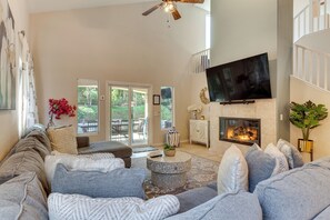 A living room with a fireplace, a flat-screen TV, and a large window. - Country Club Perks! Indio Golf Haven on Fairway (Indio)