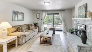 A living room with a sofa, coffee table, and fireplace. - Walk to UNM! Quiet Extended Escape w/ Patio (Albuquerque)