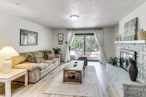 A living room with a sofa, coffee table, and fireplace. - Walk to UNM! Quiet Extended Escape w/ Patio (Albuquerque)