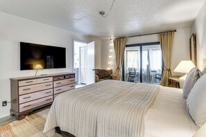 A bedroom with a large bed, a dresser, a flat-screen TV, and a view of the outdoors. - Walk to UNM! Quiet Extended Escape w/ Patio (Albuquerque)