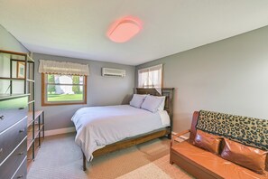 Un dormitorio con cama, cómoda, tocador y ventana con vistas.