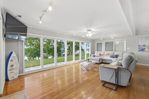 Ein geräumiges Wohnzimmer mit großen Fenstern, einem modernen Kamin und einer gemütlichen Sitzecke.