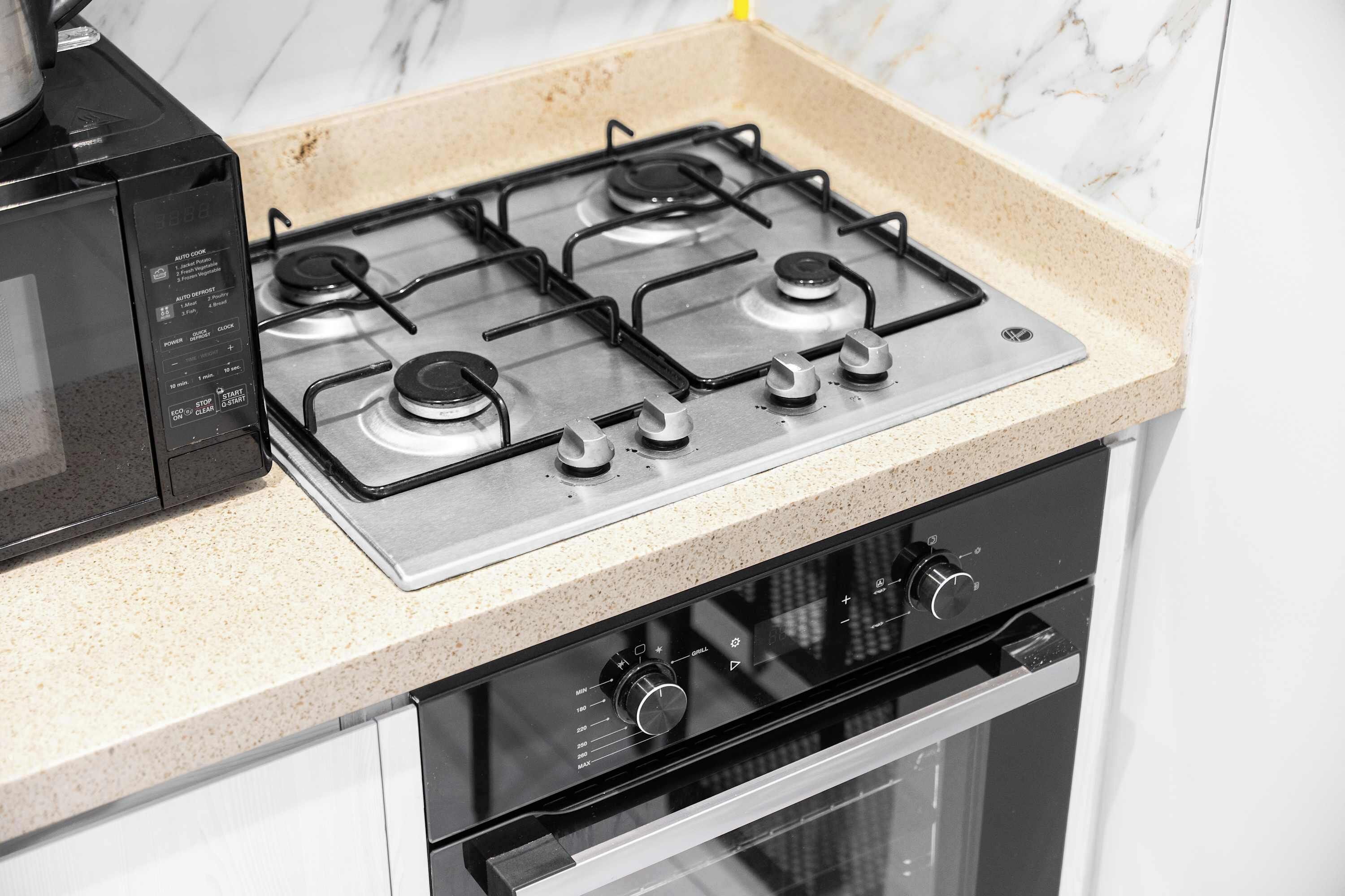 A kitchen with a gas stove, oven, and microwave.