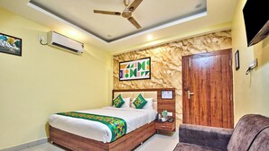 Un dormitorio con cama, mesita de noche, silla, armario, ventilador de techo y aire acondicionado instalado en la pared.