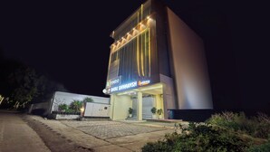 Un edificio moderno con un letrero que dice 'Treebo Baba Shivaansh Residency' de noche.
