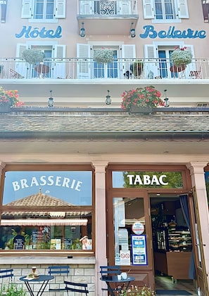A hotel with balconies, a brasserie, and a tobacconist.