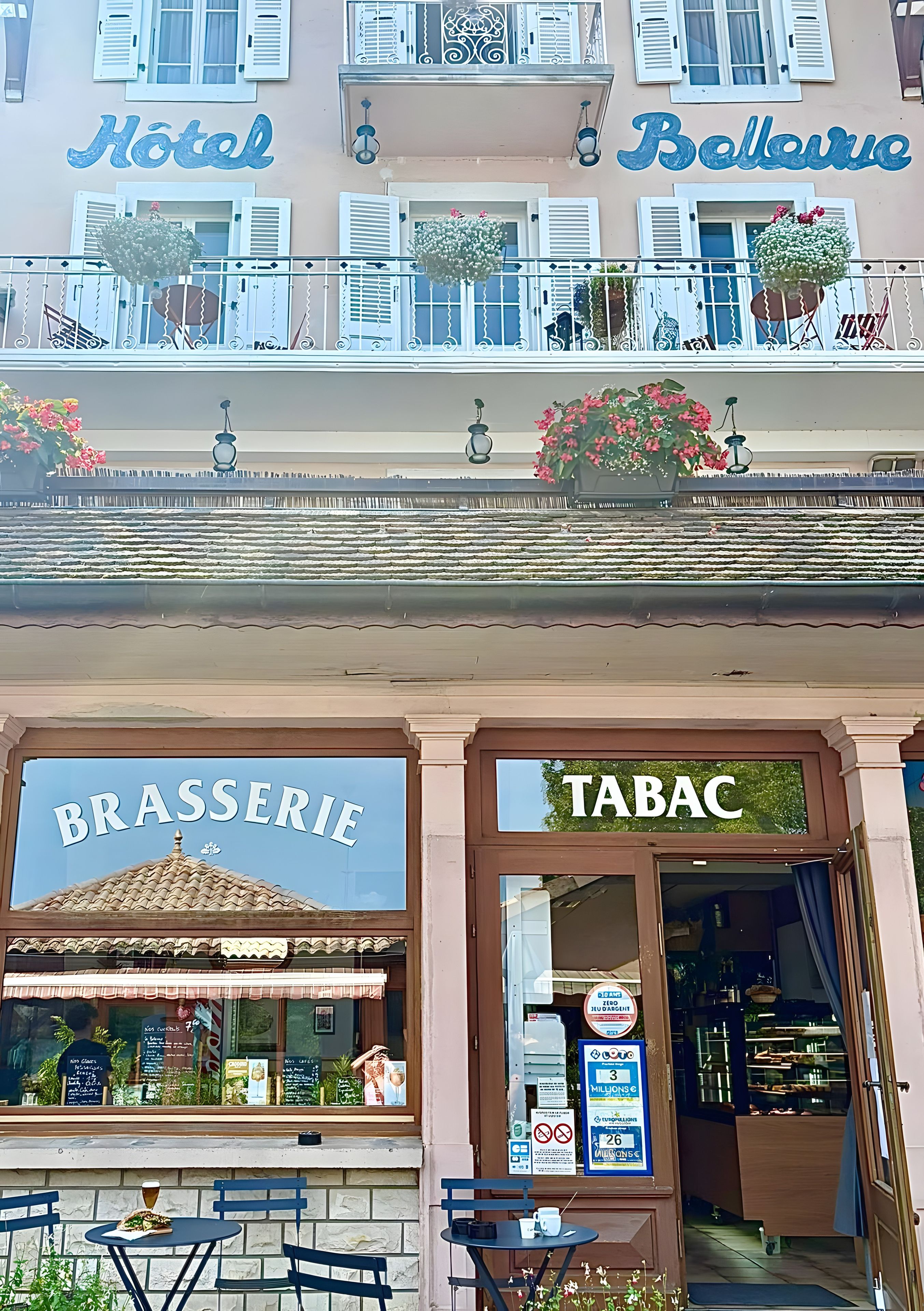 Een hotel met balkons, een brasserie en een tabakswinkel.