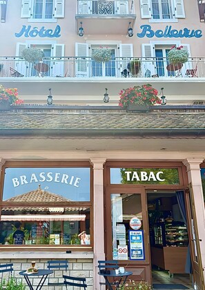 A hotel with balconies, a brasserie, and a tobacconist.