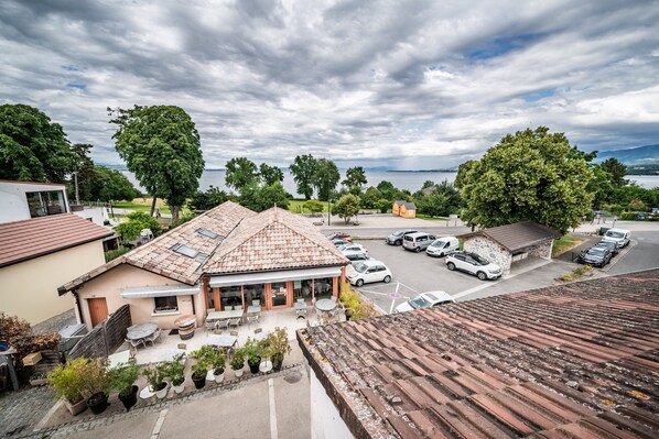 A building with a tiled roof, outdoor seating, and a parking lot.