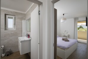Ein modernes Schlafzimmer mit Bett, Nachttisch und Fenster mit Blick.