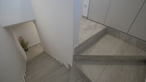 Eine moderne Treppe mit minimalistischem Design, einem Topf mit Pflanze und einer aufgeräumten Umgebung.