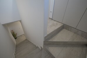 Eine moderne Treppe mit minimalistischem Design, einer Topfpflanze und einem aufgeräumten, freien Raum.