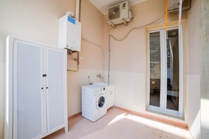 Una sala de lavandería con lavadora, secadora y calentador de agua.