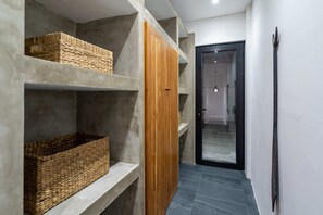 Ein Flur mit Betonschränken, Korbwägelchen und einem Holzschrank.