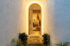 A stone staircase leading to an arched doorway with a hanging light fixture. - Villa Atlas (Legian)