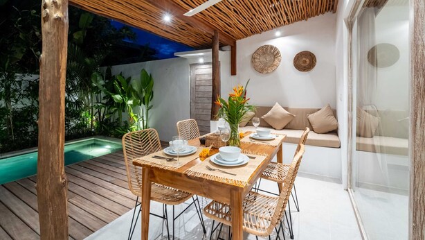 An outdoor dining area with a wooden table, wicker chairs, and a ceiling fan. - Villa Diana 3 (Tabanan)