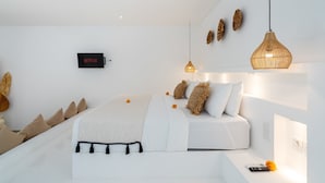 A modern bedroom with a bed, a wall-mounted Netflix sign, and a hanging light fixture. - Villa Diana 3 (Tabanan)