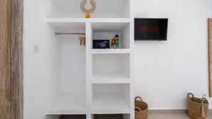 Ein weißes Regal mit einem Netflix-Schild, einem Radio und einem kleinen Kranz.