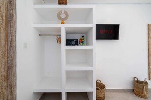 Ein weißes Regal mit einem Netflix-Schild, einem Radio und einem kleinen Kranz.