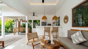 Un espacio moderno para vivir con sofá, sillas, una mesa de comedor y una cocina al fondo.