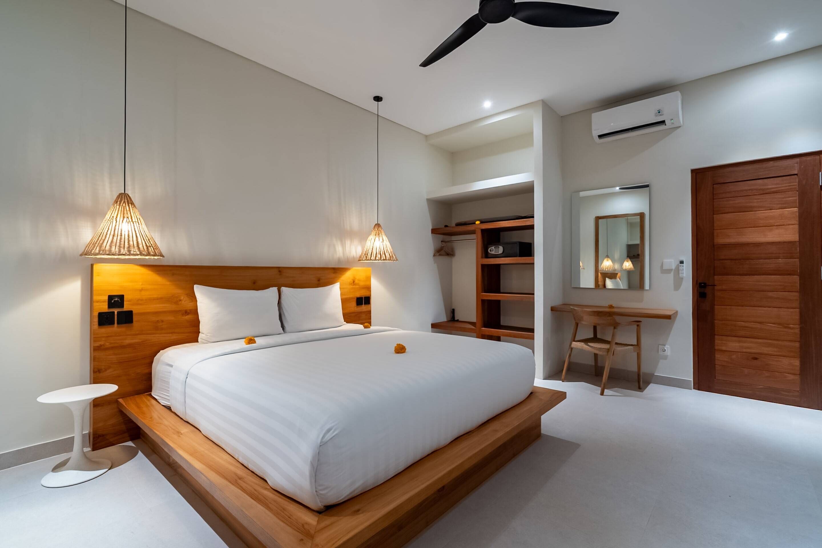 A modern bedroom with a wooden bed, bedside tables, a desk, and a wardrobe.