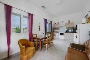 A modern kitchen with white cabinets, a microwave, and a washing machine. - Holiday Home “Le Cocon Taillonais” with Private Pool, Wi-Fi and Air Conditioning (Saint-Ciers-du-Taillon)