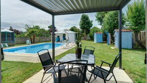 A covered patio with a pool, outdoor seating, and a small shed. - Holiday Home "Le Cocon Taillonais" with Private Pool, Wi-Fi, and Air Conditioning (Saint-Ciers-du-Taillon)