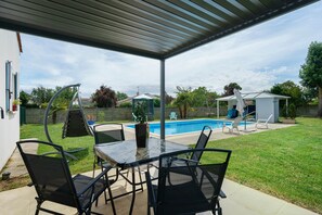 A covered patio with a pool, outdoor seating, and a small gazebo. - Holiday Home “Le Cocon Taillonais” with Private Pool, Wi-Fi and Air Conditioning (Saint-Ciers-du-Taillon)