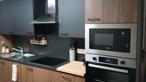 Una cucina moderna con forno integrato, microonde e cappa aspirante in acciaio inossidabile.