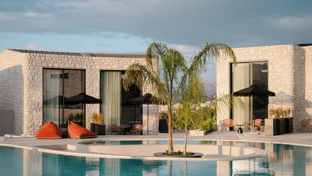 A modern poolside area with a stone building, large windows, and outdoor seating. - Standard Villa - Kyklio Pavilions Nafplio (Nafplio)