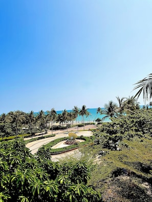 A landscaped area with palm trees, a central garden feature, and a view of the ocean. - My Marina Beach Hotel Phu Quoc (Phu Quoc)