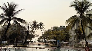 A swimming pool with palm trees, lounge chairs, and umbrellas. - My Marina Beach Hotel Phu Quoc (Phu Quoc)