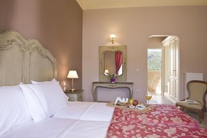Habitación de hotel con dos camas, una mesita de noche con lámpara, un espejo, una bandeja con alimentos para el desayuno y una silla.