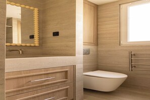 A modern bathroom with a beige vanity, a white toilet, and a mirror with a decorative frame. - Design Apartment a/c 1BR/4P - Saint-Germain (Paris)