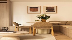 A modern living room with a round coffee table, two chairs, a sofa, and a side table. There are framed artworks on the wall and a vase with flowers on the side table. - Design Apartment a/c 1BR/4P - Saint-Germain (Paris)
