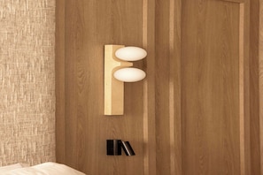 A wooden door with a modern, minimalist handle and a small, black, cylindrical object below it. - Design Apartment a/c 1BR/4P - Saint-Germain (Paris)