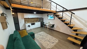 A modern apartment with a loft bedroom, a kitchen, a dining area, and a staircase. - 2 Cozy 1-bedroom apartments in  Tirana (tirana)