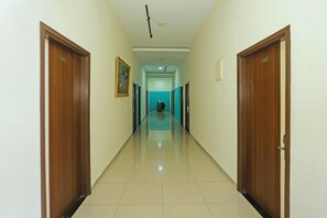 A hallway with wooden doors, a tiled floor, and a ceiling light fixture. - Luxury Twin Stay with Free WiFi and Parking (Jakarta)