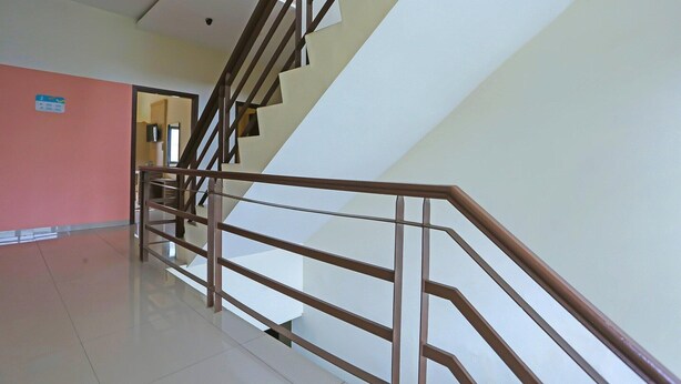A staircase with a handrail, a door leading to another room, and a sign on the wall. - Luxury Twin Stay with Free WiFi and Parking (Jakarta)