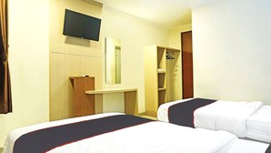 Habitación de hotel con dos camas, televisor montado en la pared, espejo y armario.