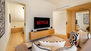 A modern living room with a flat-screen TV, a sofa, and a minimalist design. - Modern Studio for Easy Everyday Living (Lisbon)