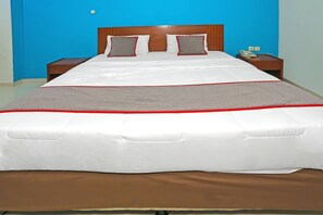 A hotel room with a large bed, two bedside tables, a telephone, and a wall socket. - Stylish DBL Suite Escape W/ Free WiFi and Parking (Jakarta)