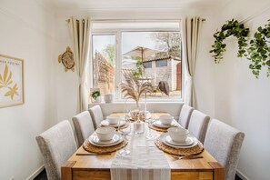 A dining area with a wooden table set for four, surrounded by upholstered chairs. - White Oak Charm House | Free Parking | 10PPL (Sheffield)