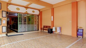 Un hall d’entrée spacieux, doté d’un sol carrelé, d’un banc en bois, d’un tableau blanc et d’une entrée décorative.