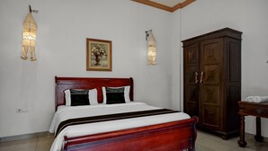 Quarto com cama de madeira, guarda-roupa e luminárias fixadas na parede.