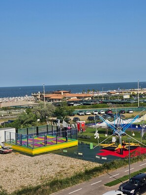 Une zone côtière comprenant une aire de jeux, une grande roue et un port de plaisance.