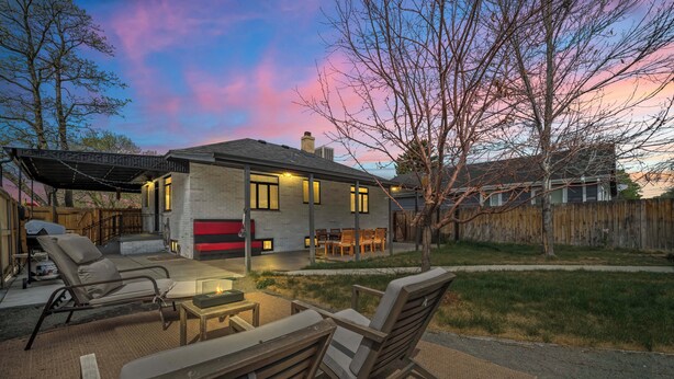 A house with a patio area, outdoor seating, and a view of the sky.