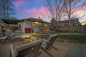A house with a patio area, outdoor seating, and a view of the sky. - Spacious Home for 7 with BBQ and Fenced Yard (Denver)