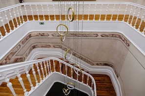 Una escalera de caracol con balaustres blancos y una pared con diseño de mármol.