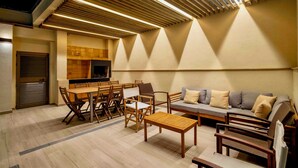 A modern interior with a dining area, sofa, and wooden furniture.